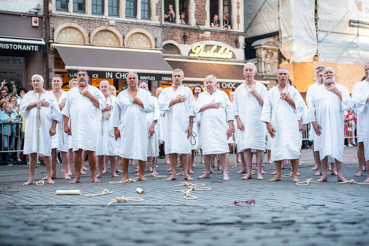 Männer in weißem Gewand mit einer Schlinge um den Hals während des Stroppenstoet der Gent -Feierlichkeiten