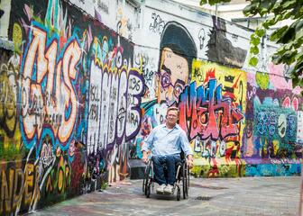 een man in een rolstoel in het graffitistraatje