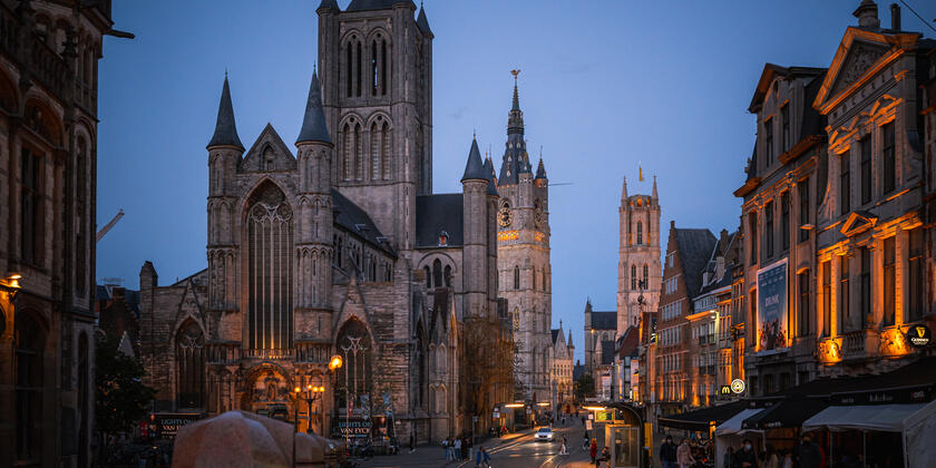 De drie torens van Gent verlicht bij valavond